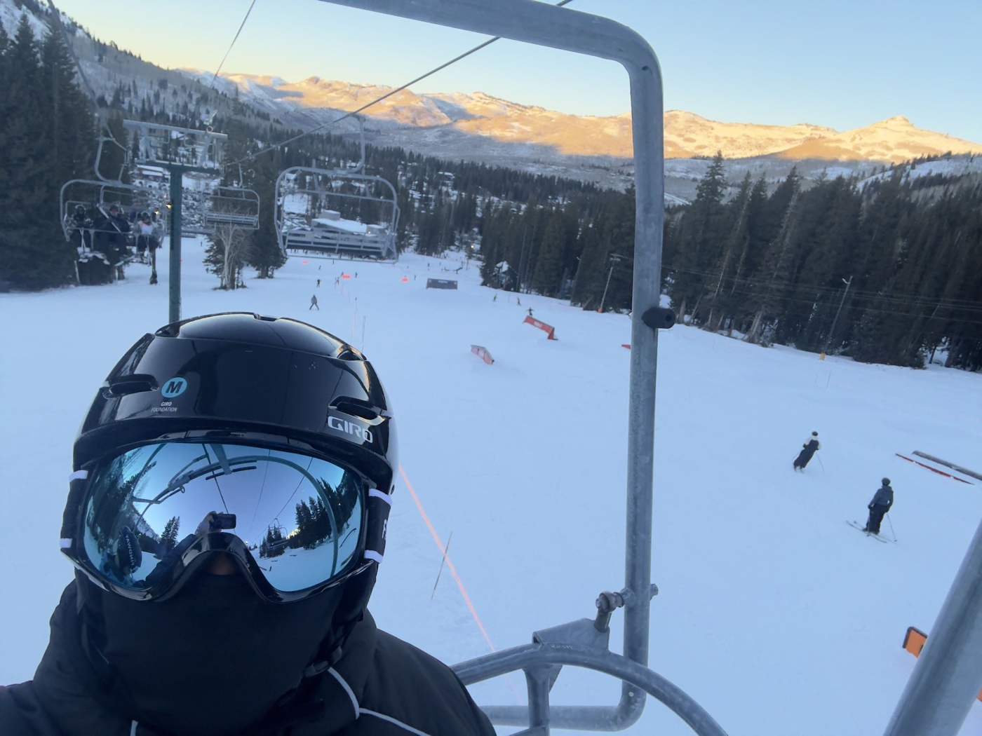Rishi on a chairlift above snowy mountain slopes